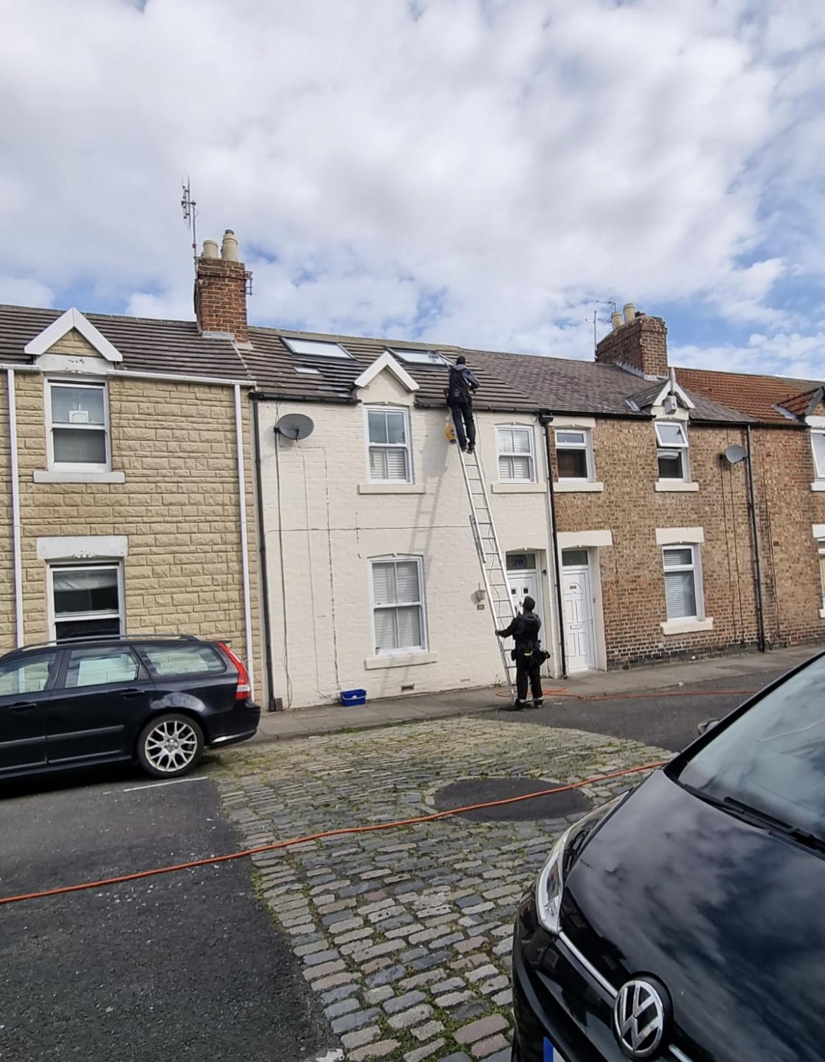 A Rob Gibson cleaner working from a ladder on a terraced street
